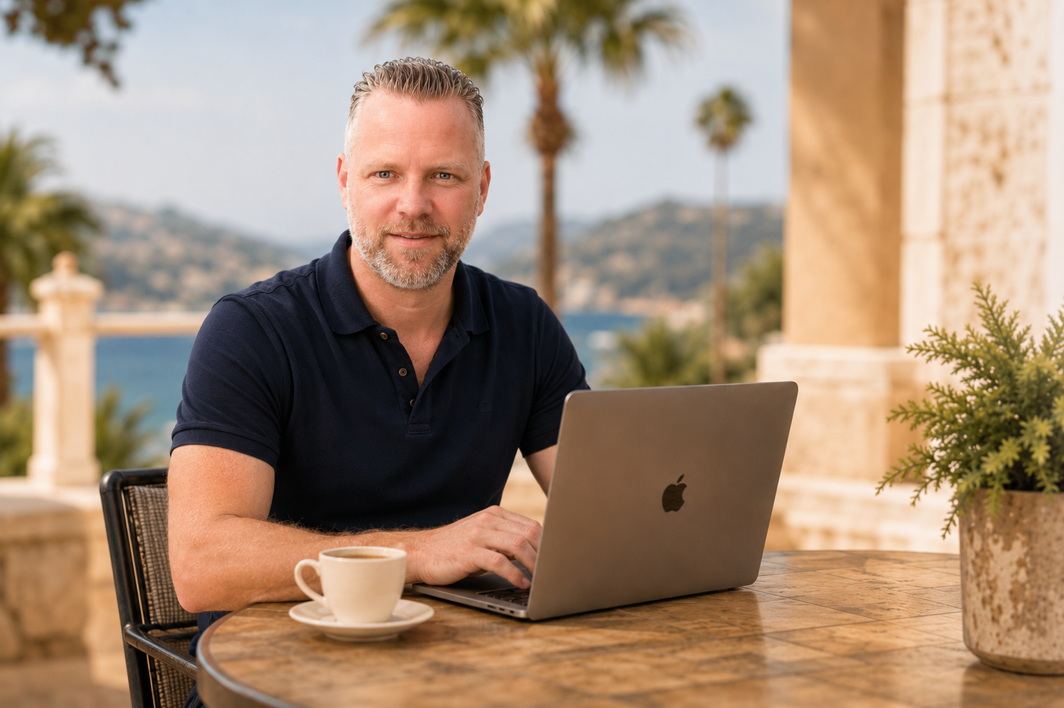 Thijs working on a laptop on a terrace by the Mediterranean